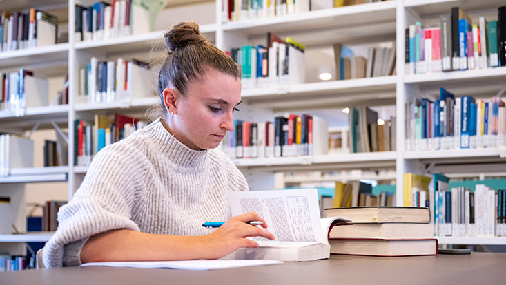 Studentin lernt in einer Bibliothek