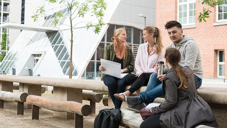 Vier Studierende unterhalten sich auf dem Campus Berliner Tor