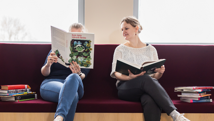 Zwei Studierende lesen in der BIbliothek im Philturm